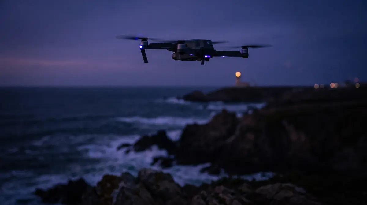 A folding drone hovers above a coastal cliff at twilight with dark ocean below