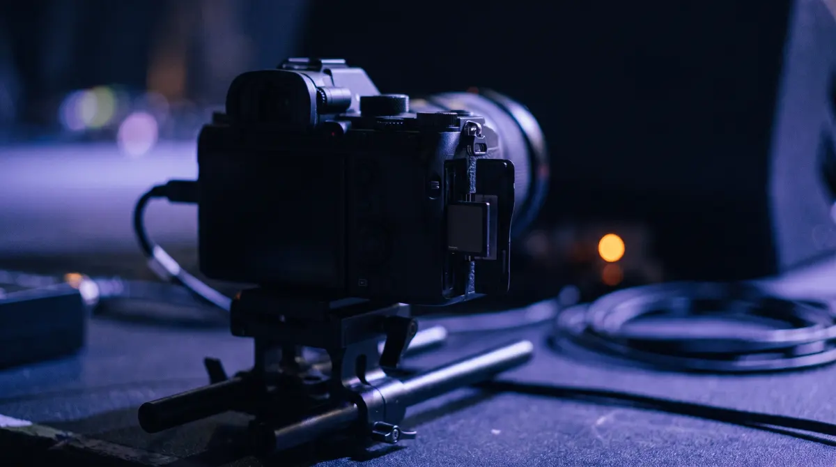 A compact cinema camera on a rig, a memory card half ejected from its slot